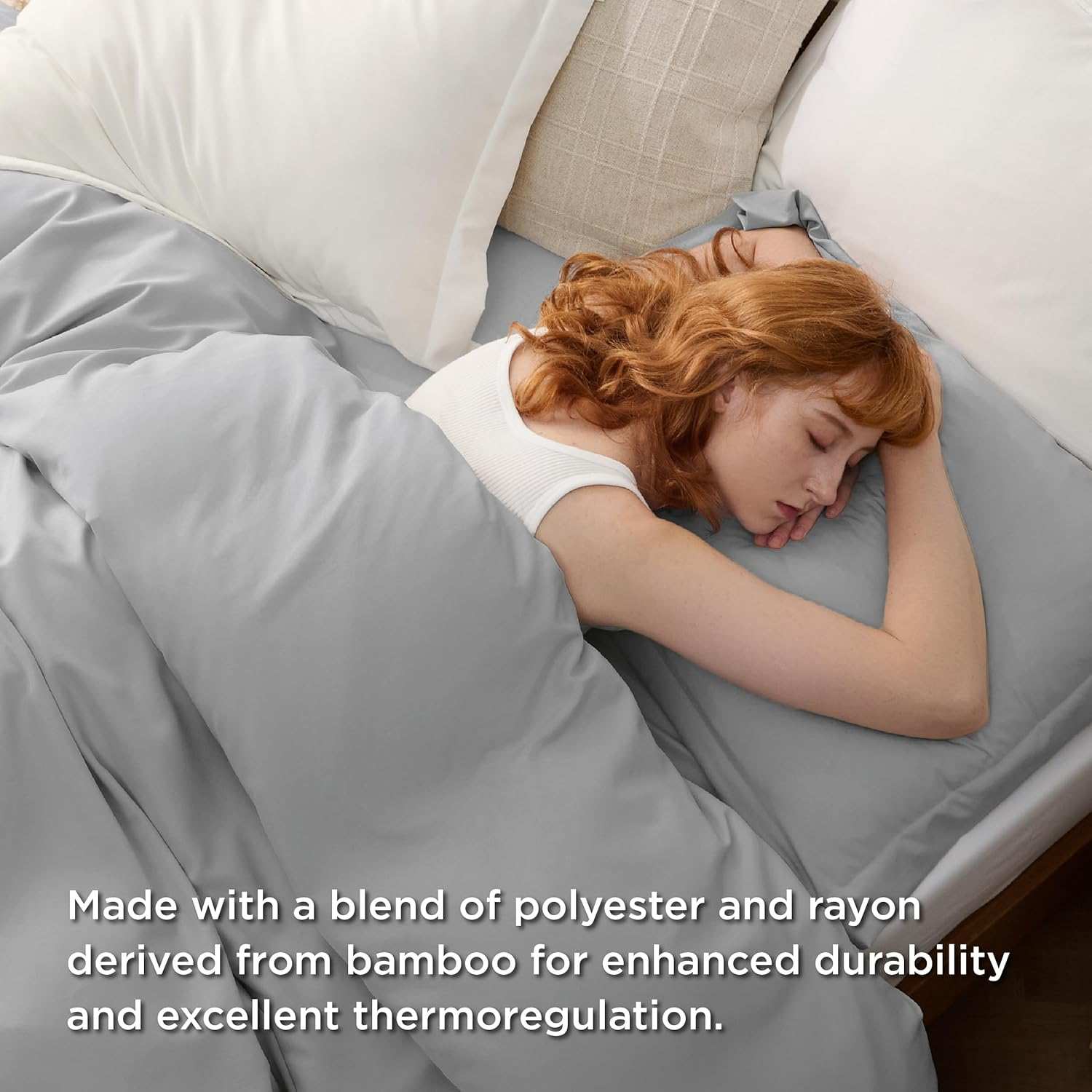 Woman sleeping comfortably on gray bed sheets made with a blend of polyester and rayon from bamboo for enhanced durability and thermoregulation.