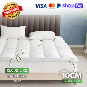 White quilted mattress topper on a luxurious bed with a tufted headboard, showcasing its plush padding and premium quality for enhanced comfort.