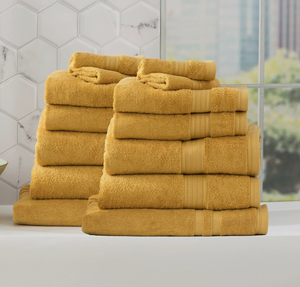 Stack of plush yellow towels in a modern bathroom setting.