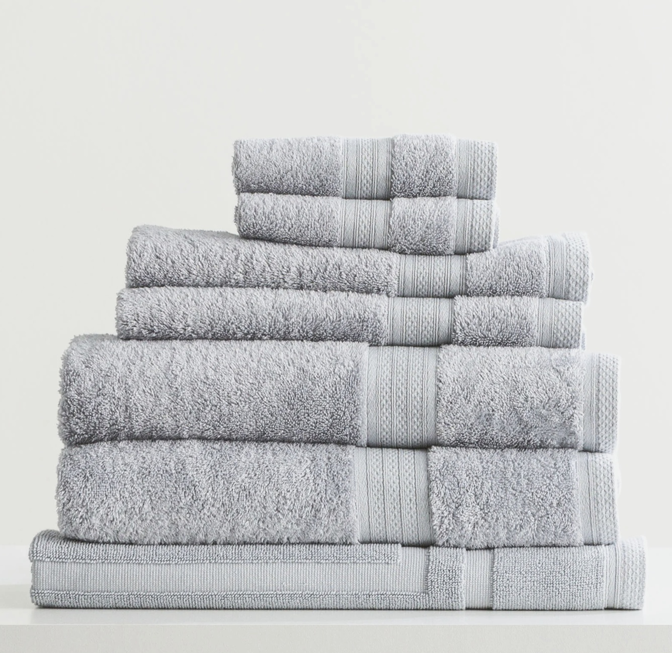 Stack of folded gray towels on a white background